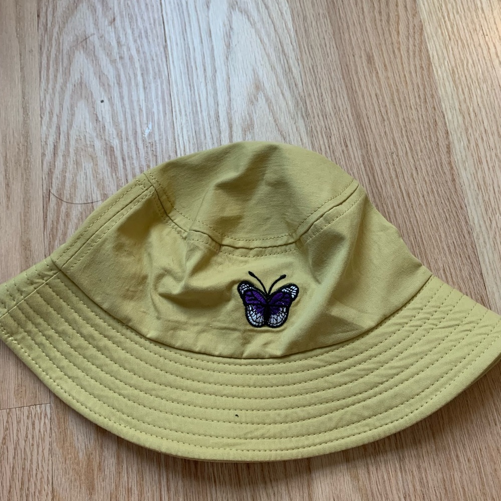 Yellow bucket hat with a purple butterfly on the front.